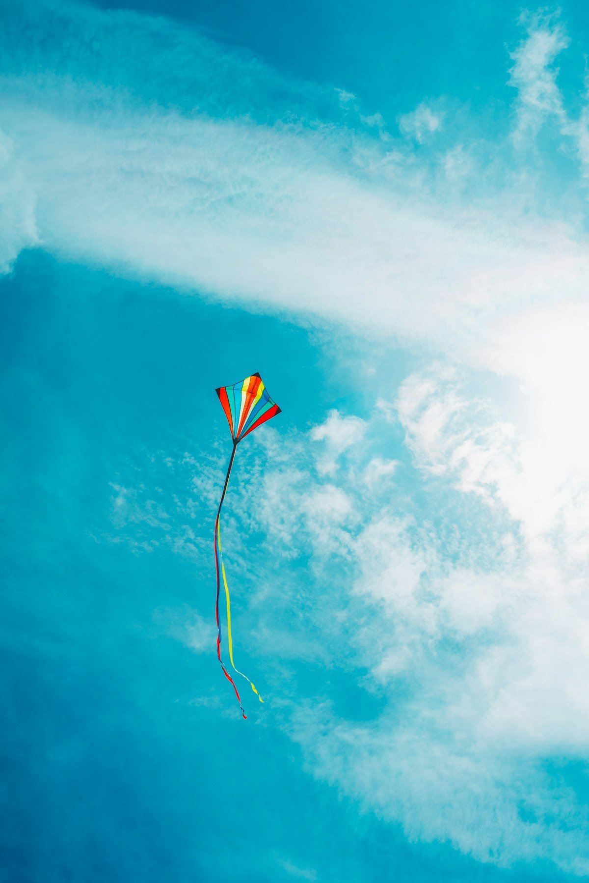 A handcrafted kite flying against a vivid blue sky